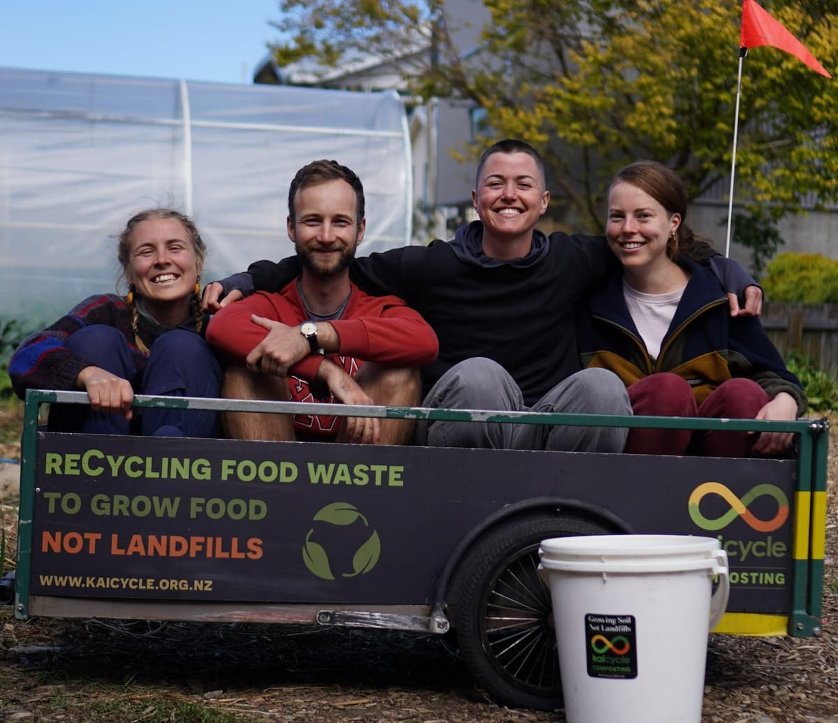 A group of Kaicycle volunteers sitting in a trailer, smiling for the camera