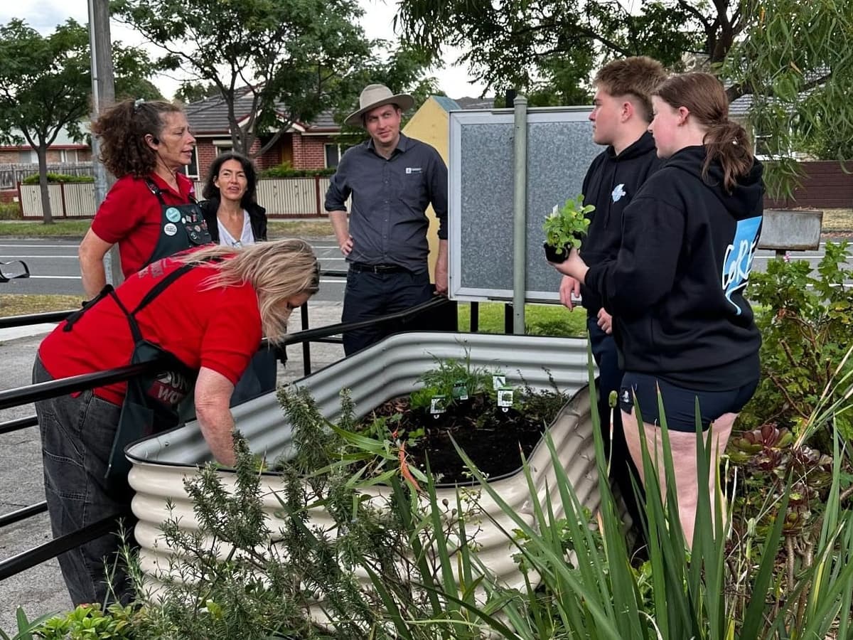 A group of volunteers gathered around a garden bed